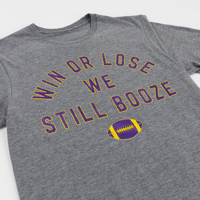 Graphite gray t-shirt with purple and yellow text that reads "Win or Lose We Still Booze" with a football, set against a white background.