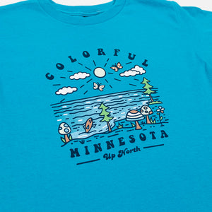 Blue t-shirt with a graphic design of trees, mushrooms, and text on a white background