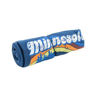 A rolled-up blanket with a Minnesota design against a white background.